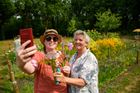 Foto van twee bezoekers van Fieflora die glimlachend poseren met zelfgeplukte bloemen